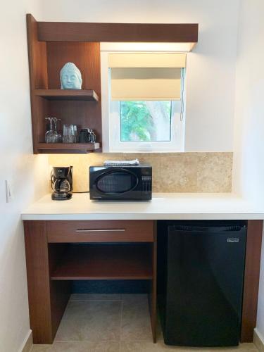 a kitchen with a counter with a microwave and a dishwasher at Sand Castle on the Beach - Adults Only in Frederiksted