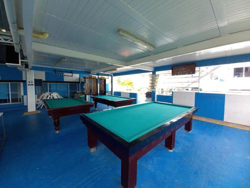 two pool tables in a room with blue floors at Hotel Barcelona Chinauta in Chinauta