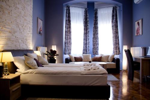 a bedroom with a bed and a couch in a room at La Pergola & Prestige Panzió in Kaposvár