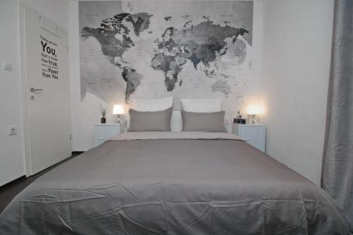 a bedroom with a large bed with a world map on the wall at Carrera Corner Apartment in Rovinj