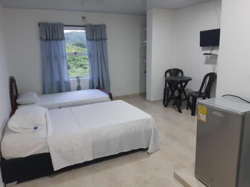 a bedroom with a bed and a table and a window at Cabaña Villa Carmen in Juan de Acosta