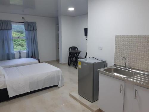 1 dormitorio con 1 cama y lavamanos. en Cabaña Villa Carmen, en Juan de Acosta