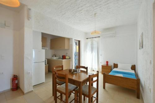a kitchen and dining room with a table and a bed at Galini Apartments in Achlia