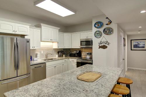 a kitchen with white cabinets and a granite counter top at Channelview 206 in Port Aransas
