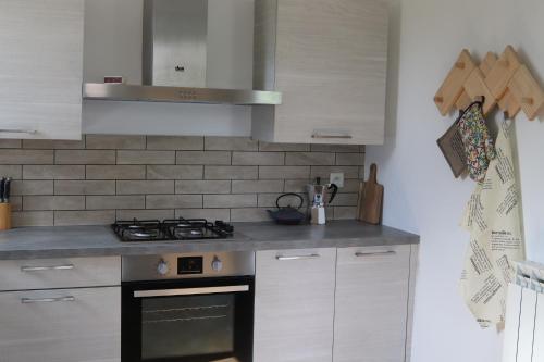 a kitchen with white cabinets and a stove top oven at Chambres d'hôtes "HOR DAGO" près de la gare d'Hendaye avec le petit-déjeuner in Hendaye
