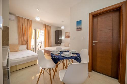 a room with a table and chairs and a bedroom at Kristal Apartmani in Čanj