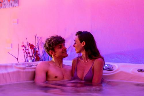 un hombre y una mujer sentados en una bañera en Hotel Dusseldorf, en Rímini