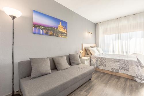 a living room with a couch and a bed at Apartment Hispalis Salado in Seville