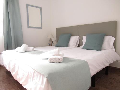 dwa duże białe łóżka z ręcznikami na górze w obiekcie NÁUTICO Boutique Apartments, by Comfortable Luxury - Adults Only w Corralejo