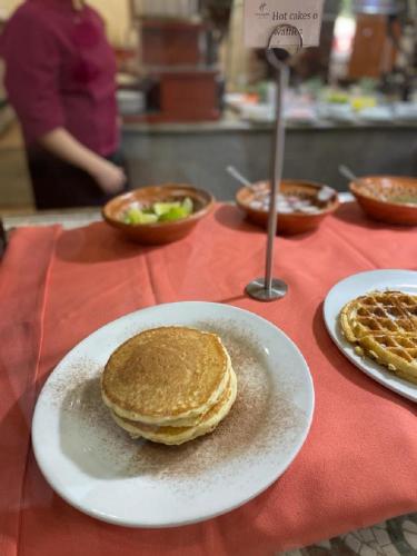 a table with pancakes on a plate on a table at Ramada by Wyndham Ciudad de Mexico Perinorte in Mexico City