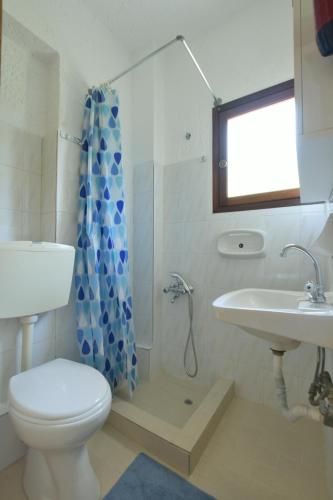 a bathroom with a toilet and a sink at Galini Apartments in Achlia