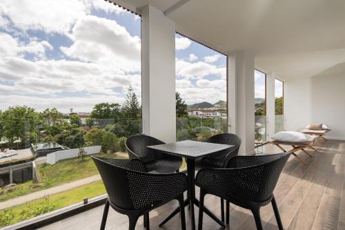 a dining room with a table and chairs and a large window at Senhora da Rosa, Tradition & Nature Hotel in Ponta Delgada