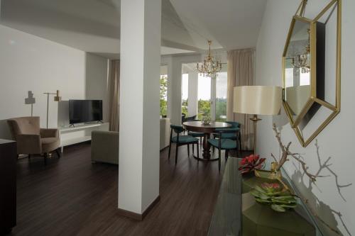 a living room with a table and a mirror at Senhora da Rosa, Tradition & Nature Hotel in Ponta Delgada
