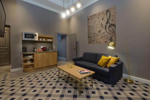 uma sala de estar com um sofá azul e uma mesa em KH Opera Apartments em Viena
