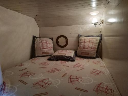 Una cama en una habitación pequeña con escritura roja. en Korriganez - Festival Interceltique, en Lorient