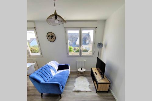 a living room with a blue couch and a tv at Charmant T1 bis dans un quartier calme in Brest