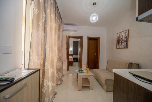 eine Küche und ein Wohnzimmer mit einem Sofa in der Unterkunft Kristal Apartmani in Čanj
