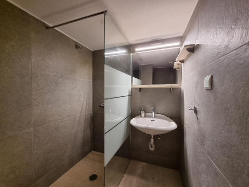 a bathroom with a sink and a glass shower at Melas Apartments in Agios Nikolaos
