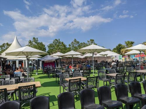 a group of tables and chairs with umbrellas at Mobil home Stéfie in Vias