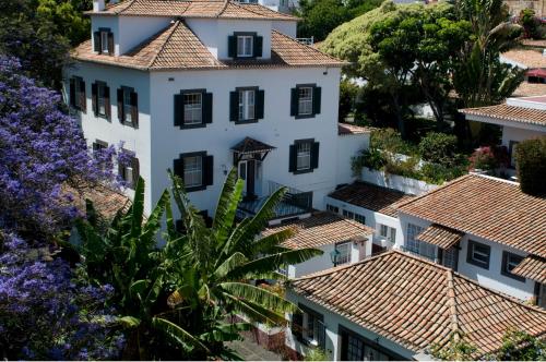 a view of a white house with red tile roofs at Quinta Da Penha De Franca in Funchal