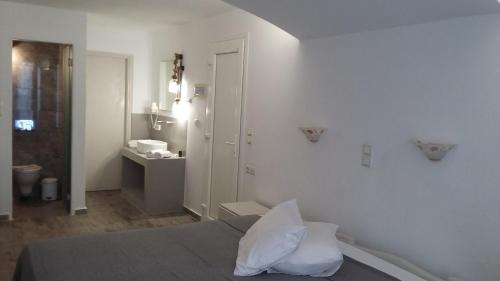 a white room with a bed and a bathroom at Blue Sky Summer in Naxos Chora