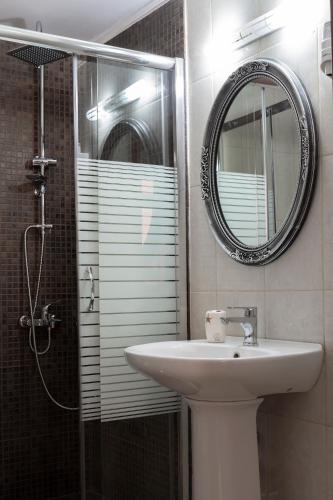 a bathroom with a sink and a shower with a mirror at Narkissos 'SUPERB' in Chania Town