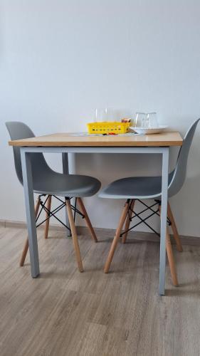 a table with two chairs and a yellow bowl on it at Apartments Swan Lake in Kyiv