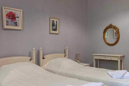 a bedroom with two twin beds and a mirror at Narkissos 'SUPERB' in Chania Town
