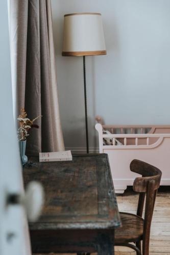 a table with a lamp and a chair in a room at Maison Séraphine - Guest house - Bed and Breakfast in Laon