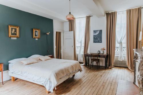 a bedroom with a bed with a green wall at Maison Séraphine - Guest house - Bed and Breakfast in Laon