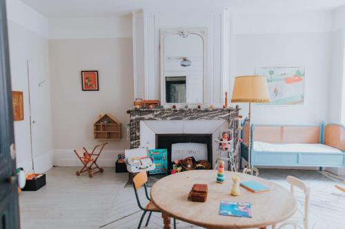 a living room with a table and a fireplace at Maison Séraphine - Guest house - Bed and Breakfast in Laon