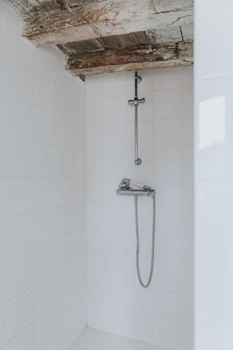 a shower in a white bathroom with a wooden ceiling at Maison Séraphine - Guest house - Bed and Breakfast in Laon