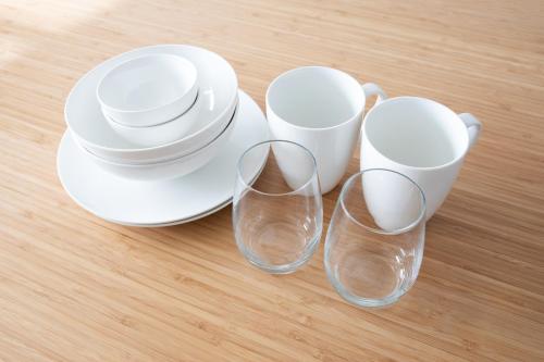 three empty wine glasses and plates on a table at Laffitte Hirai Condominium Hotel in Tokyo