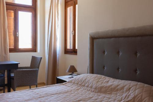 a bedroom with a bed and a desk and a window at Narkissos 'SUPERB' in Chania Town
