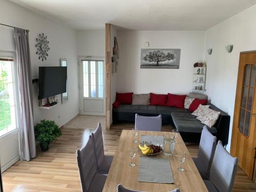 ein Wohnzimmer mit einem Tisch und einem Sofa in der Unterkunft Apartmani Bilić in Dugi Rat