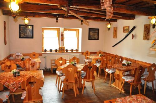 um restaurante com mesas e cadeiras de madeira e janelas em Penzion Leštiny em Dolný Kubín