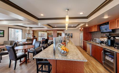 a kitchen and dining room with a counter and chairs at Canalta Rocky Mountain House in Rocky Mountain House