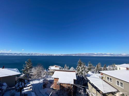 arial view of a town with snow covered buildings and a lake at Villa Fania in Ohrid