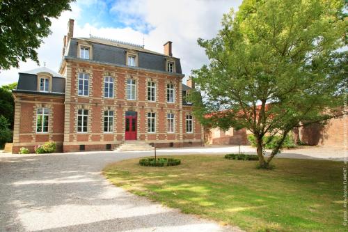 duży ceglany budynek z drzewem przed nim w obiekcie VILLA VARENTIA w mieście Villers-Bretonneux
