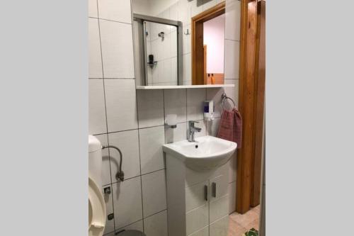 a white bathroom with a sink and a mirror at Quiet & Cozy Studio apartment on Baščaršija in Sarajevo