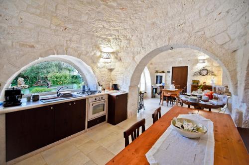 eine Küche und ein Esszimmer mit einem Tisch und einem Torbogen in der Unterkunft B&B Masseria Nuove Caselle in Villa Castelli