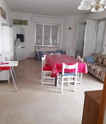 salon z czerwonym stołem i krzesłami w obiekcie Donatella Mare w mieście Tortoreto Lido