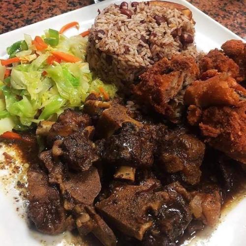 a plate of food with meat and vegetables on a table at Arms of Charms Guesthouse in Sandy Bay