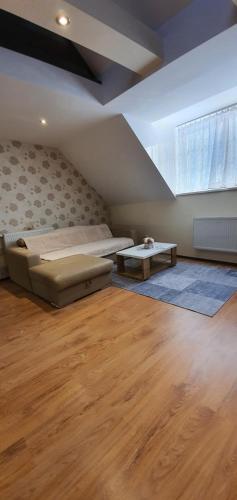 a bedroom with a bed and a couch and a table at ApartmanyStocklova2 in Bardejov