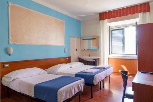 a hotel room with two beds and a table at Hotel America in Milan