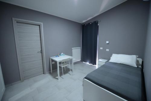 a small bedroom with a bed and a table at Sonia e Alessia in Mileto