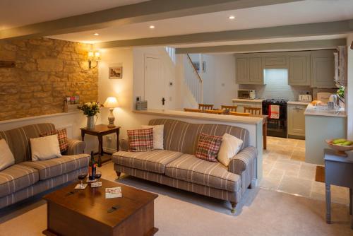 a living room with two couches and a kitchen at Hook Cottage in Chipping Campden