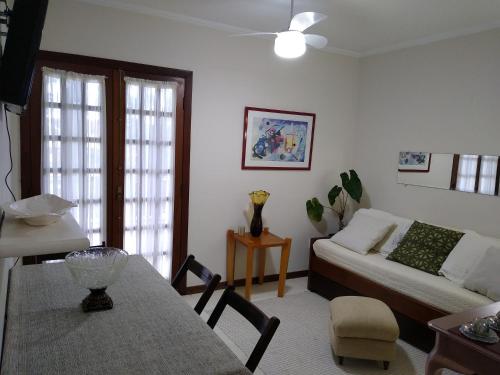 a living room with a couch and a table at Flat Bairro Nobre - Bertioga in Bertioga