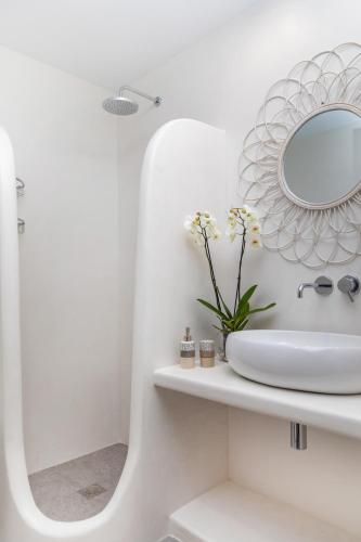 a white bathroom with a sink and a mirror at Dolce Vita appartments in Naxos Chora