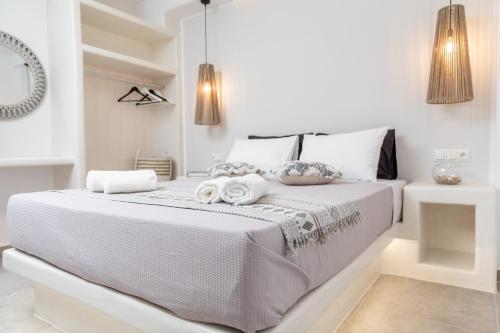 a white bedroom with a bed with towels on it at Dolce Vita appartments in Naxos Chora
